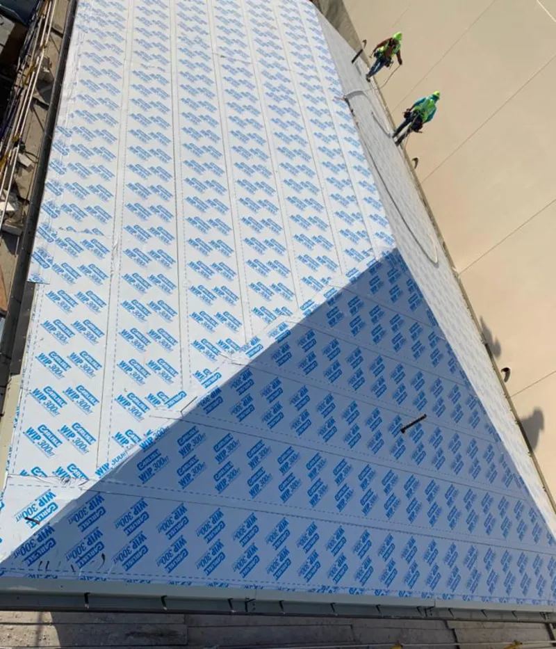 Professional roofers installing underlayment on a metal roof in Jamesburg